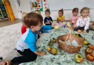 chłopiec wkłada do kosza jabłko