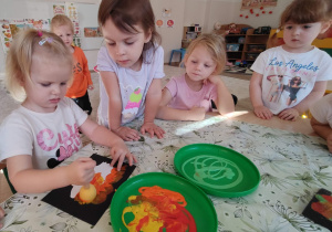 dziewczynka stempluje farbą wokół obrazka