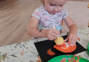 dziewczynka wykonuje swoja pracę plastyczną
