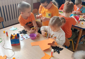 dzieci rysują, wycinają i naklejają