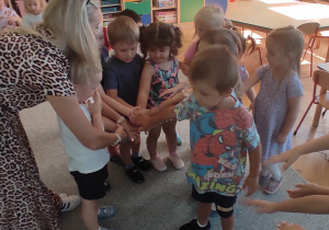 dzieci składają dłonie do wspólnego okrzyku