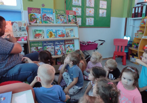 dzieci oglądają ilustrację w książce o Przygodach Pucia