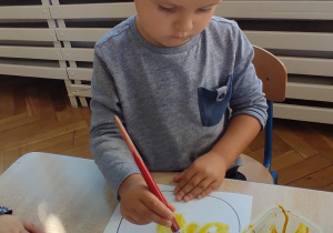 Ignaś maluje farbą gruszkę