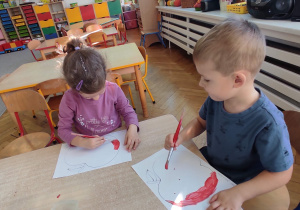 Zuzia i Antoś malują farbą jabłka