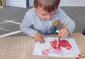 Filip maluje farbą jabłko