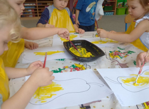 dzieci malują żółtą farbą szablon gruszki
