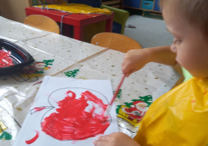 chłopiec maluje farbą szablon jabłka