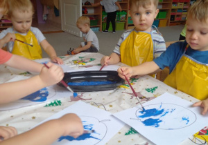 dzieci malują niebieską farbą śliwkę