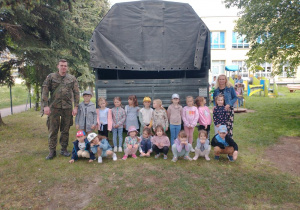 zdjęcie grupowe za samochodem wojskowym