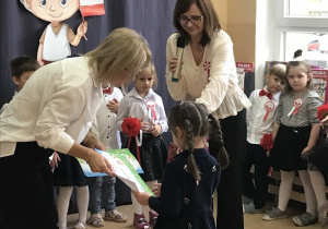 Pani dyrektor wręcza dziecku nagrodę i dyplom