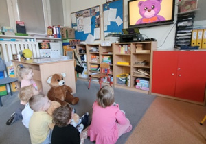 Dzieci oglądają bajkę edukacyjną o historii pluszowego misia.