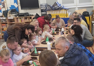 Dzieci wykonują ozdobę świąteczną - choinkę - wspólnie z rodzicami.