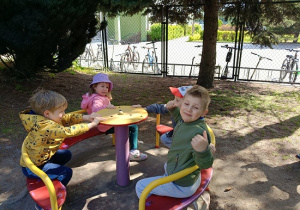 dzieci huśtają się na karuzeli