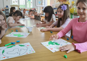 dzieci kolorują rysunek kuli ziemskiej