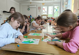 dzieci kolorują rysunek kuli ziemskiej