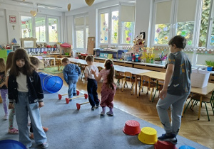 dzieci pokonują przeszkody ustawione ze sprzętu gimnastycznego
