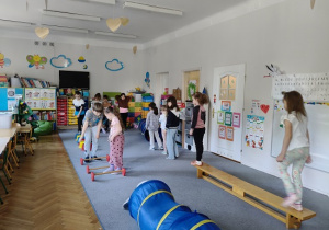 dzieci pokonują przeszkody ustawione ze sprzętu gimnastycznego