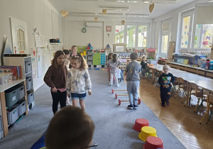 dzieci pokonują przeszkody ustawione ze sprzętu gimnastycznego