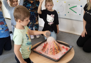 dzieci biorą udział w eksperymencie wulkan