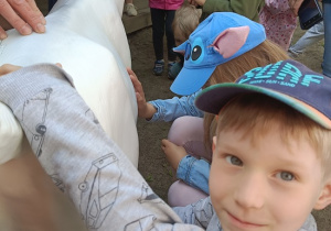 dzieci doją zabawkową kozę