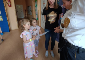 dziewczynki wręczają podziękowanie strażniczkom