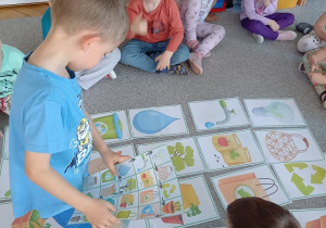 chłopiec chodzi po zakodowanej trasie obrazków ilustrujących elementy ziemi