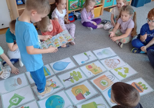 chłopiec chodzi po zakodowanej trasie obrazków ilustrujących elementy ziemi