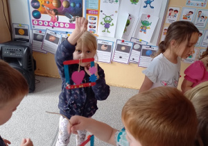 dziewczynka prezentuje wykonaną laurkę z kolorowych patyczków