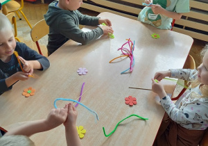 dzieci z drucików kreatywnych wykonują kwiatki