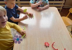 dzieci z drucików kreatywnych wykonują kwiatki