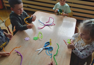 dzieci z drucików kreatywnych wykonują kwiatki