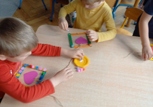 dzieci z drucików kreatywnych wykonują kwiatki