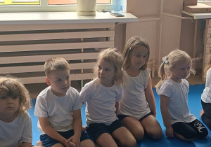 dzieci siedzą w grupie na zajęciach judo