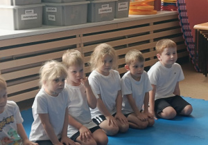 dzieci siedzą w grupie na zajęciach judo