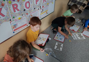 dzieci układają obrazki na tablicach magnetycznych