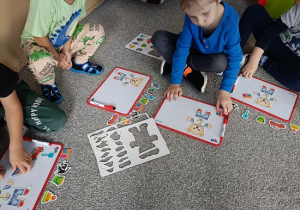 dzieci układają obrazki na tablicach magnetycznych