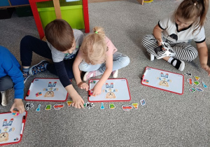 dzieci układają obrazki na tablicach magnetycznych