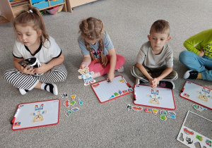 dzieci układają obrazki na tablicach magnetycznych