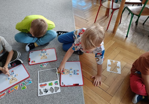 dzieci układają obrazki na tablicach magnetycznych
