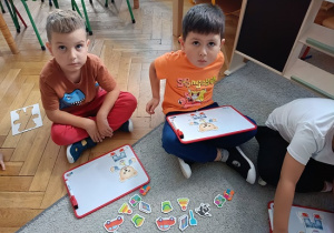 dzieci układają obrazki na tablicach magnetycznych
