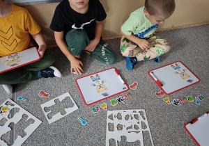 dzieci układają obrazki na tablicach magnetycznych