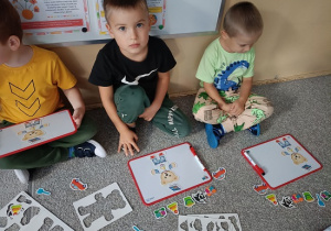 dzieci układają obrazki na tablicach magnetycznych