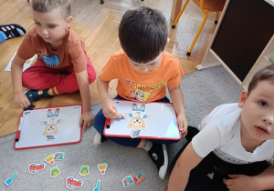dzieci układają obrazki na tablicach magnetycznych