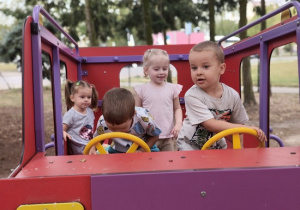 dzieci kierują zabawkowym samochodem