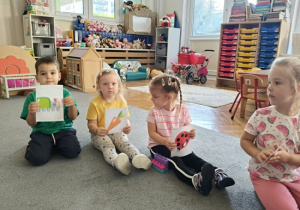 dzieci pokazują swoje przydzielone znaczki na obrazkach