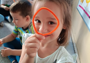 dziewczynka układa literkę "o" z drucika kreatywnego