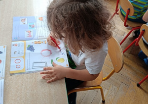 chłopiec rysuje przy stoliku w książce