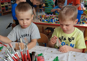 chłopcy malują czerwoną farbą