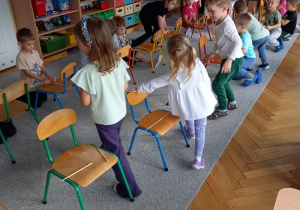 dzieci chodzą wokół krzesełek