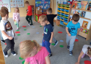 dzieci maszerują po kolorowych kropkach